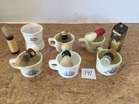 All six mugs and seven brushes laid out