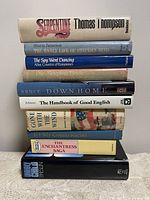 Stack of 10 hardcover books, showing titles on spines including 'Serpentine,' 'The Early Life of Stephen Hind,' 'The Snow Went Dancing,' 'The Sleeping Bride,' 'Down Home,' 'The Handbook of Good English,' 'Gone with the Wind,' 'My Cousin Rachel,' 'The Enchantress Saga,' and 'Unholy Child.'
