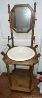 Full view of the antique wooden washstand with octagonal mirror and ceramic wash basin