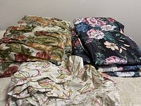 Three different floral fabric types folded and stacked next to each other.