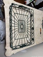 Top view of the green wire tray showing the leaf and vine design on the edges and open wire grid base.