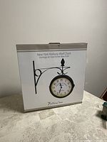 Box packaging showing New York Railway Wall Clock with design image and text.