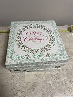 Stack of four original Royal Doulton Christmas collector plate boxes, labeled Merry Christmas with holly design.