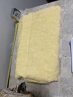 Light yellow fabric folded showing color and texture with measuring tape indicating approximately 54 inches wide.