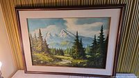 Framed oil painting showing full mountain landscape and frame