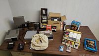 Wide view of vintage electronics on table showing multiple devices, tapes, and accessories.