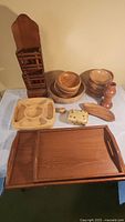 Photo showing entire lot of wooden items including bowls, trays, wall rack, pepper grinder, and decorative items.