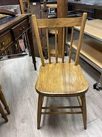 Front view of traditional wooden chair showing natural finish and minor wear.