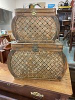 Front and side view of two vintage woven bamboo and wood picnic storage boxes stacked, showing design and latch closure