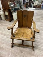 Front view of the antique wooden chair with wicker seat and natural wood finish.