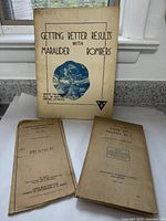 Three vintage military-related items: a booklet about Marauder Bombers and two fold-out maps, placed on a flat surface beneath a window.