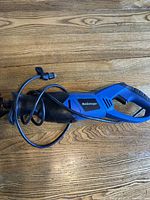 Full side view of the Mastercraft Sawzall reciprocating saw lying horizontally on wooden surface.