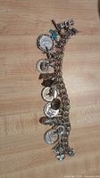 Full view of bracelet laid flat showing multiple attached charms on silver chain