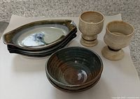 Full view of two pedestal mugs, two ceramic bowls, and four serving dishes stacked