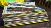 Stack of vintage MAD and CRACKED magazines, showing titles including 'The Sound of MAD', 'Fighting MAD', and 'The Voodoo MAD'. Magazines are stacked horizontally, with some visible signs of wear along the spines and edges.