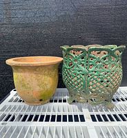 Front view of the antique metal planter next to the terracotta insert, showing their size and condition