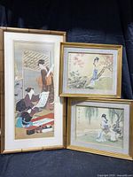 Three framed Asian art pieces displayed on dark fabric background. Includes one large vertical print and two smaller framed watercolors.