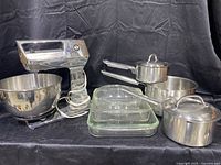 Full view of vintage Hamilton Beach mixer with stainless steel bowl, two Pyrex baking pans, and three stainless steel pots with lids, showing all items in the lot
