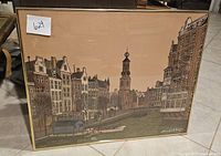 Framed Denis Paul Noyer print showing a cityscape with stylized buildings and a clock tower, signed and numbered 255 of 260.