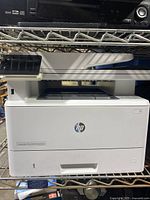 Front view of HP LaserJet Pro MFP M426fdn showing paper trays labeled 1 and 2, output area, and HP logo.