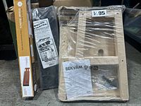 Photo of the boxed drawer organizer, board stacker, and shrink-wrapped wooden stool parts with instruction manual and hardware.