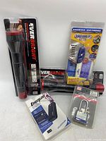 Lot contents showing two EverBright flashlights, Energizer power bank, Engrave-It Pro engraver, and a metal padlock all in packaging.