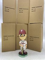 Six boxed Philadelphia Phillies bobbleheads with one displayed outside the box.