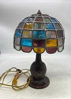 Front view of the stained glass lamp shade with multicolor glass panels and metal framework.