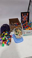 Overview of various toys including Gogo's Crazy Bones spilling from a purple bag, mini soldiers, Expandagon connectors, and other toys in containers.