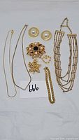 All vintage goldtone costume jewelry items displayed on white background