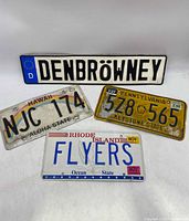 Four vintage license plates: German, Hawaii, Pennsylvania, Rhode Island.