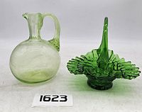 Side-by-side photo showing vintage green glass pitcher and green glass ruffled basket with handle.