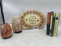 Overall view of the salt lamps, decorative sign, and books in the zen-themed lot