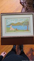 Full framed artwork showing stylized serene landscape with animals near lake and hills.