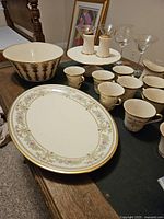 Overview of Lenox Castle Gardens vintage china tea set including cups, saucers, serving platter, bowl, cake plate, serving stand and glassware