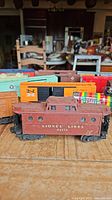 Overall set of 12 vintage Lionel train cars arranged on table showing various boxcars and caboose