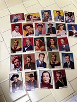 Various vintage trading cards featuring classic Hollywood actors and actresses laid out on a tiled surface.