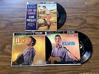 Three vintage Elvis Presley EP vinyl records with original covers featuring Elvis on the front, record partially visible.
