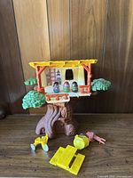 Front view of vintage tree house with three Weebles on balcony and accessories on tabletop