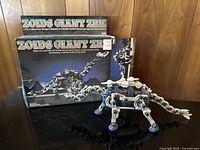 Full view of the Zoids Giant ZRK 5039 mechanical dinosaur model with original box in background on wooden surface.