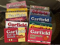 Top view of the full set of 12 Garfield comic books, showing colorful covers with Garfield in various humorous scenes.