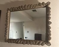 Front view of vintage large wall mirror showing silver leaf embossed leaf pattern on frame