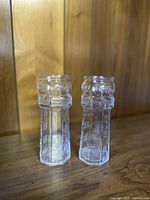 Pair of tall clear glass drinking glasses shaped like lighthouses with embossed Red Lobster text and nautical boat chain design.