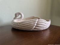 Side view showing the swan's curved neck and detailed feather texture on the side.