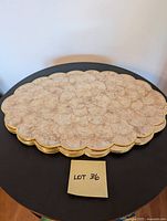 Stack of six oval scalloped-edge placemats made of cream Capiz shells with gold trim, showing the lot quantity and condition.