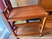 Front view of three-tier teak bar cart showing top, middle, and bottom shelves and overall condition