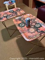 Two of the retro floral print TV trays set up side by side, showing colorful 70s floral pattern tops with a can placed on one tray.