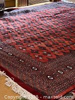 Full view of red wool carpet on wood-paneled floor