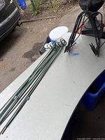Photo of green metal fence planter brackets in a row on a table