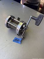 Full view of the fishing reel showing the handle and spool with fishing line.